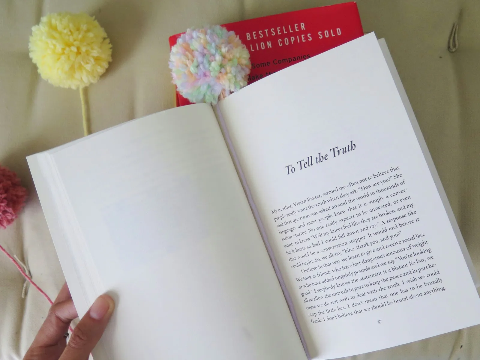 A pompom bookmark within the page of a book