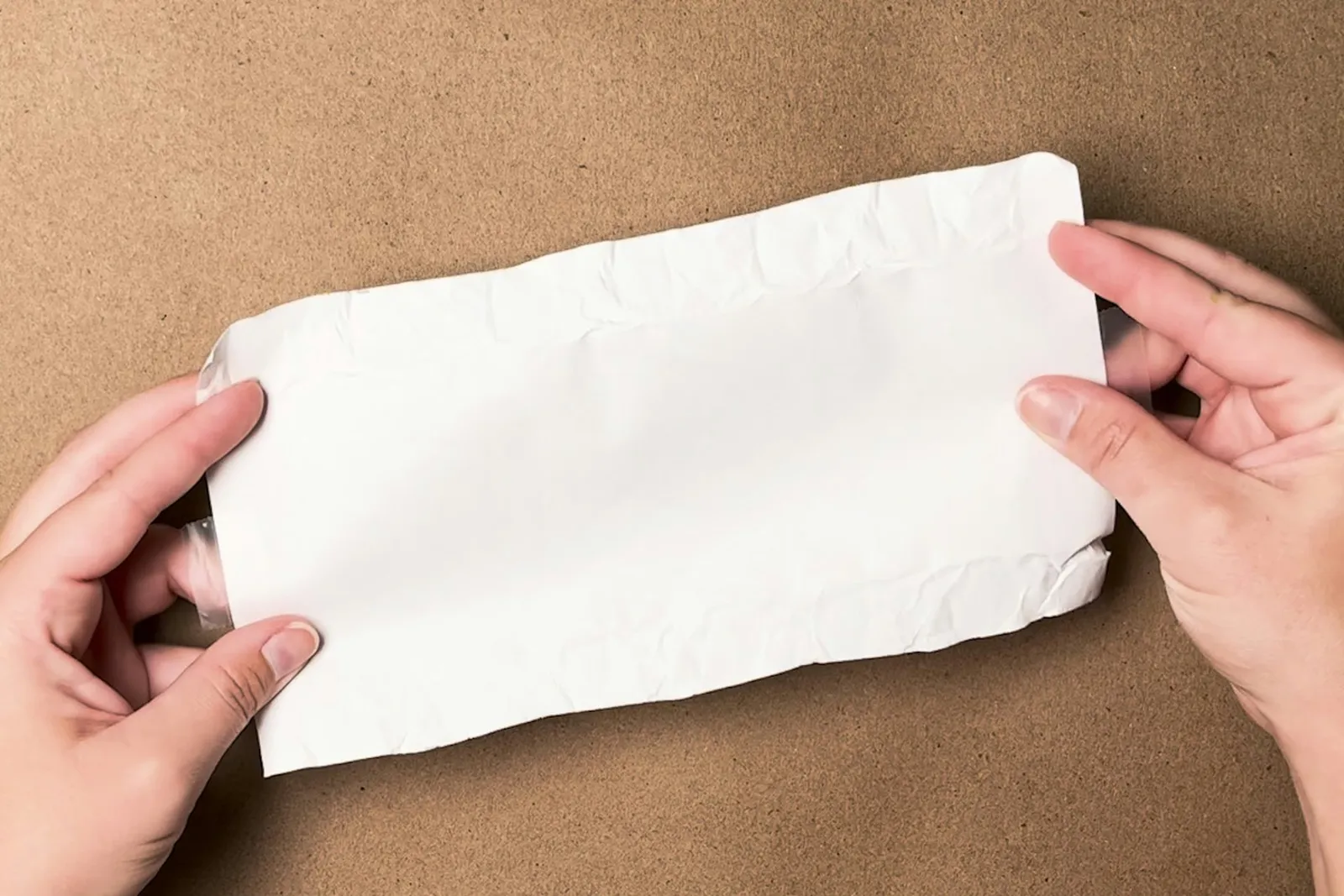 An unwrapped piece of paper cut to the dimensions of a coin wrapper