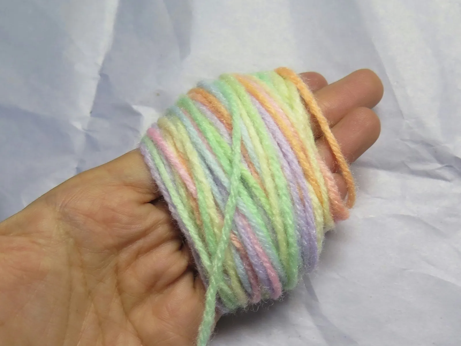 An image of yarn wrapped 90 times around four fingers.