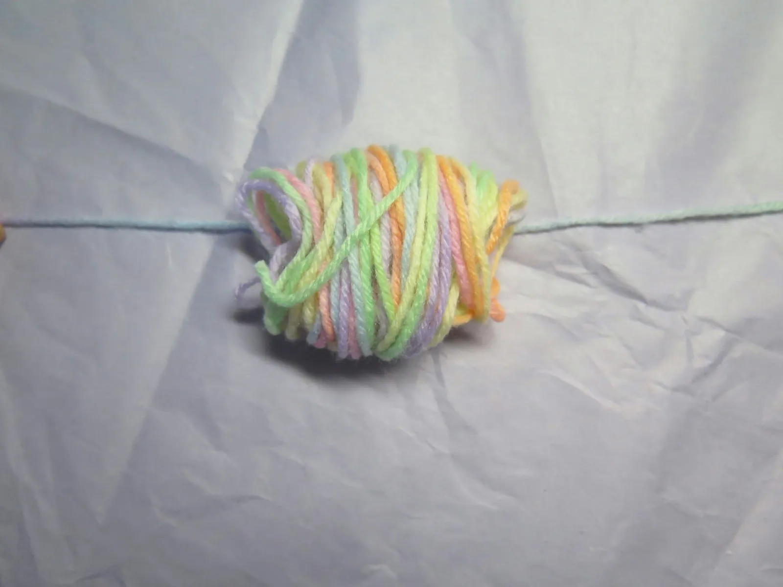A bundle of yarn placed upon a single strand of yarn