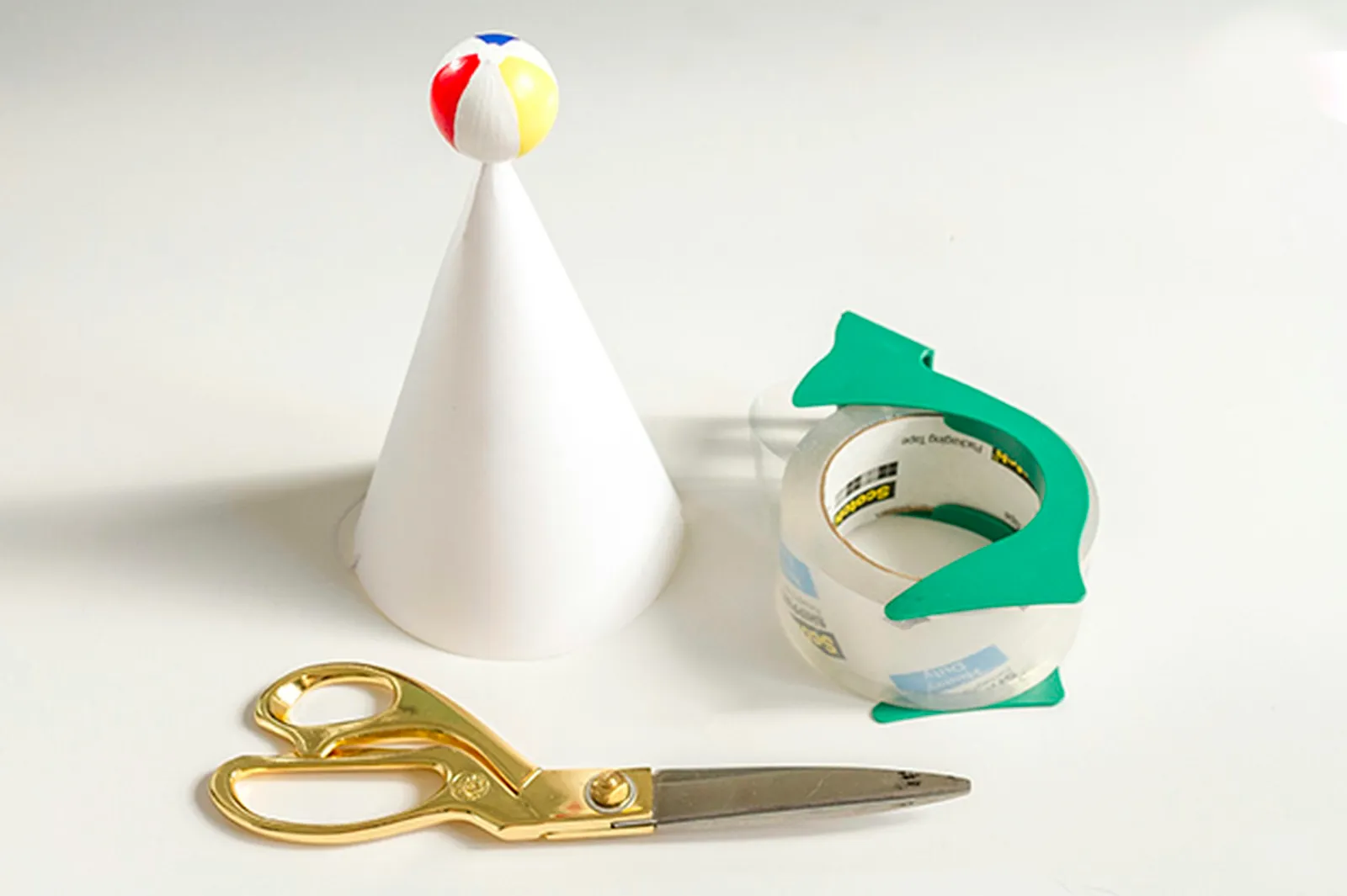 Use a wire and packaging tape to adhere the ball to the top of the hat.