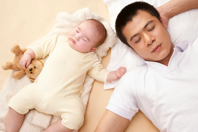 Father and baby (3-6 months) sleeping side-by-side
