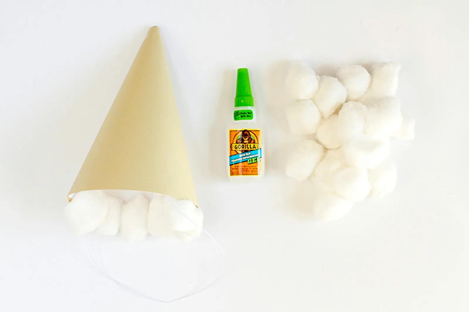 Use glue to attach cotton balls to the rim of the paper hat to mimic ice cream scoops.