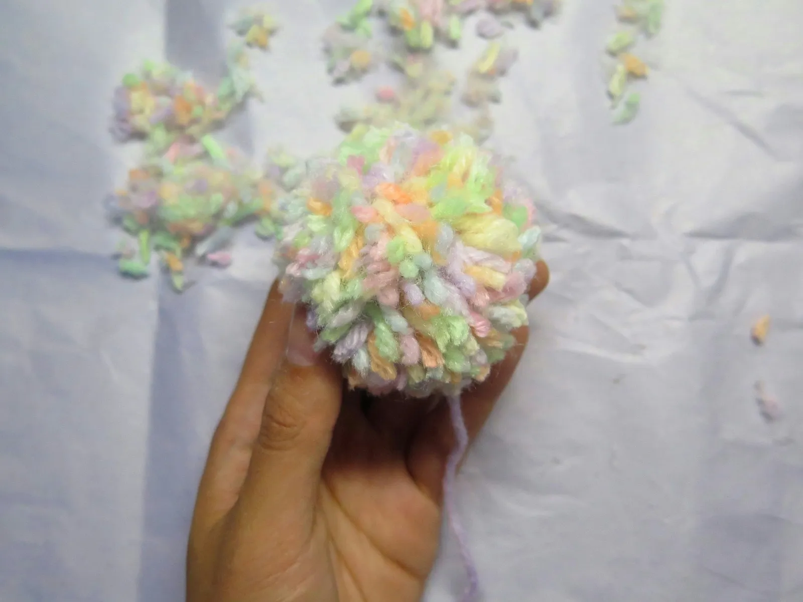 Hand holding a yarn pompom