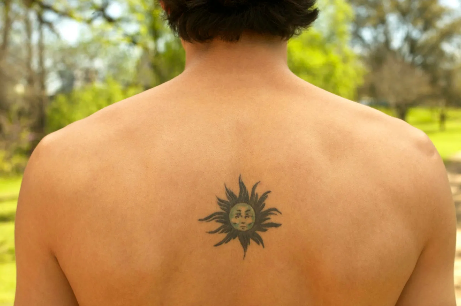 Man with sun tattoo on his back