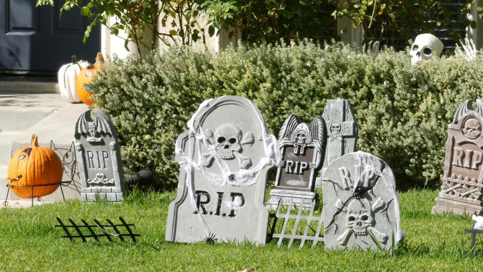 Scary festival decorations of a house, Happy Halloween holiday. Classic garden with Pumpkin, Bones and Skeleton. Traditional party decor. American culture