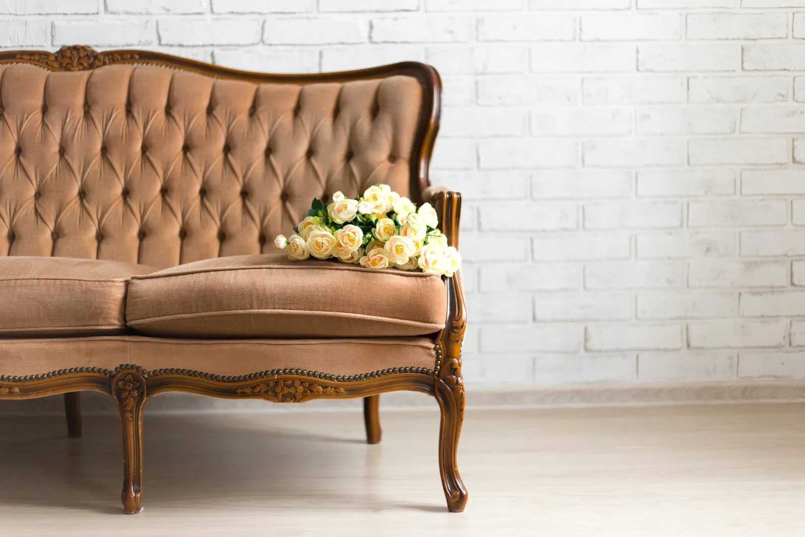 vintage sofa with flowers over white brick wall
